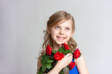 cute child 7-8 years old, mother's daughter, pretty little girl, girl with blond hair, with red roses gifted on women's day