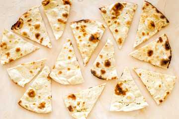 Focaccia pieces background on beige table top-down