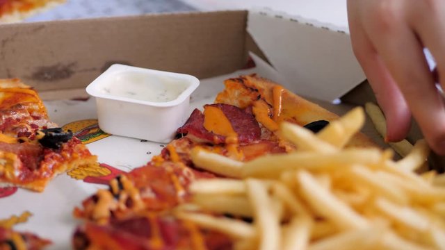pizza delivery. children dip the fries in white sauce