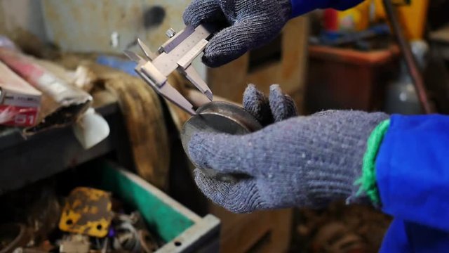 Hand close-up of a mechanic to use vernier caliper for measurement scale of a pulley