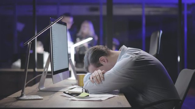 Tired young businessman sleeping in office.
