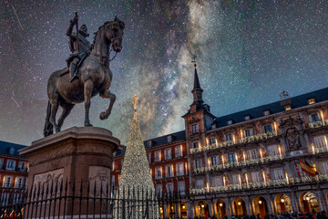 Madrid, bronze statue of King Philip III against a starry night sky and illuminated christmas tree...