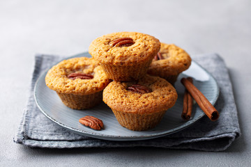 Pecun nut muffins on a plate. Grey background. Close up.