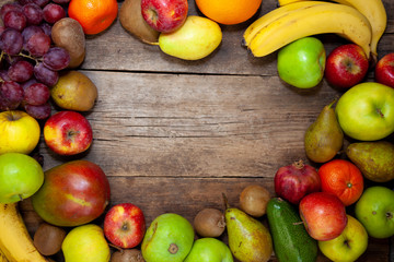 Fruit frame with space for text,  fruits on a wooden kitchen table. Assorted fruits, set. Different multi-colored fruits. Vitamin nutrition.