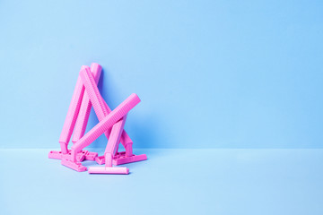 Disposable female pink razor on a blue background. A tool to remove hair from the skin. Female depilation and hygiene. Body care. Top view, copy space, stylish magazine concept