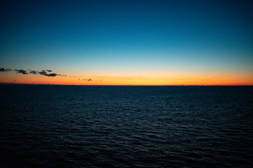 Obraz premium Sunset showing a golden or orange horizon with a dark blue sky.