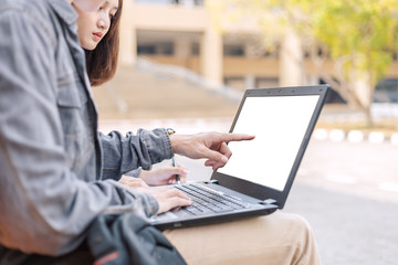 teenager sitting on stair together and hands pointing at screen laptop  doing homework.