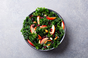 Kale salad with apples, cranberry and nuts. Grey background. Top view. - 327868084