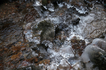 Lód na zamarzniętym górskim potoku płynie szybko nurt rwący skaliste dno © Maciek