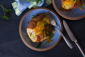 Twice Baked Potatoes with Bacon, Cheese and  Scallion. Potato in jacket. Overhead horizontal image