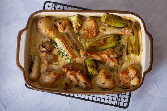 Chicken thighs and legs in sour cream sauce with leek and thyme. Overhead horizontal image