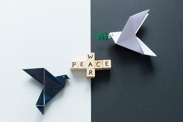 Words War and Peace and white and black paper doves.