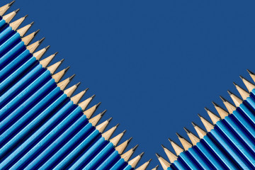 Simple pencils in blue on a blue background. Pencils lie diagonally. Background of blue classic color.