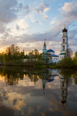 Panoramic view of the Raifa monastery from the lake. Sunset sky. Mirror reflection in the water. Beautiful russian nature. 