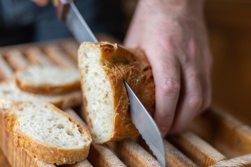 fresh bread cut with knife, wooden board for bread, sliced white whole grain bread