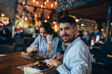 man and woman couple eating in restaurant