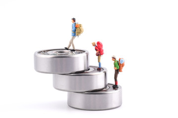 Miniature People : Three traveler walk up to ball bearing which have Lithium grease (NLGI 3) isolated on white background. Industrial and business concept.