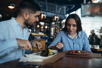 man and woman having lunch in restaurant