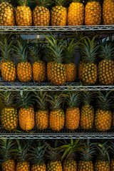 Pineapples on shelves in market ready for sale. Pineapple background.