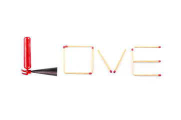 Text love made of unburned matches and a miniature fire extinguisher