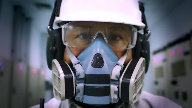 A worker wearing a Multi-purpose respirator half mask for protection gas and dust. Industrial and safety concept