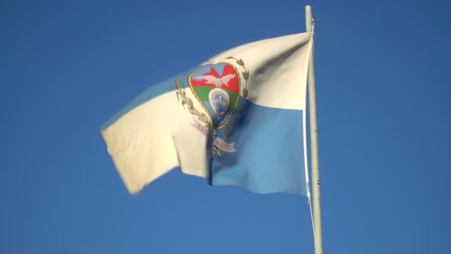 Beautiful flag of Rio de Janeiro state waving in the wind on sunny summer day with blue sky. Concept of state, symbol, republic, Brazil, cultural identity, democracy, geography and politics.