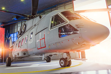 Helicopter in hangar with open gates for repair and production.