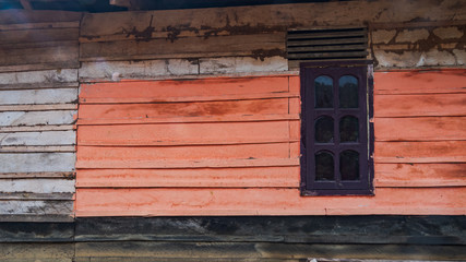 Rustic coral orange wooden house wall in rural Asia