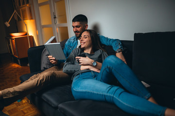 Obraz premium couple reading book relaxing on sofa at home