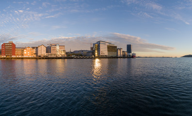 BODØ, NORDLAND COUNTY / NORWAY – May 27, 2018: Jakhelln Brygge at the lower square illuminated by the evening sun. Here seen from the harbor pool.