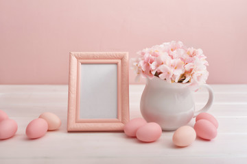 Spring and Easter holiday concept with copy space. Template Easter Greeting Card. Easter eggs and flowers on white background. Easter decoration with eggs. Photo frame and vase with flowers