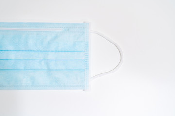 Surgical mask with rubber ear straps. Typical 3-ply surgical mask to cover the mouth and nose. Procedure mask from bacteria. Protection concept.