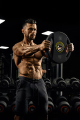 Fototapeta na wymiar Bodybuilder holding weights straight out.