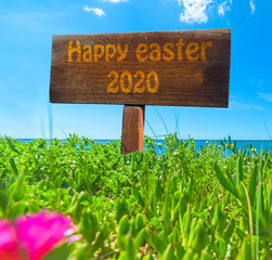 Happy easter 2020 written on a wooden sign