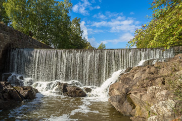 Obraz premium The picturesque view of Vanhakaupunki, the oldest part of Helsinki. The artifical waterfall of the hydroelectric power station