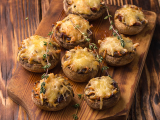 baked mushrooms with cheese on a wooden board.