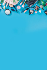 Professional makeup cosmetic set, with summer tropical leaves, woman bag. Make up items. luxury decorative cosmetics flatlay, top view, mockup. Beauty blogger concept. Trendy turquoise background