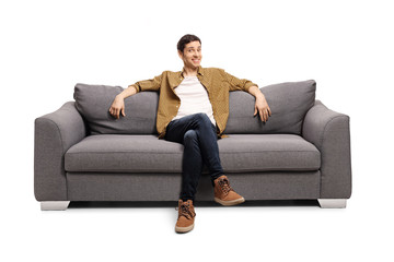 Young man sitting on a gray sofa
