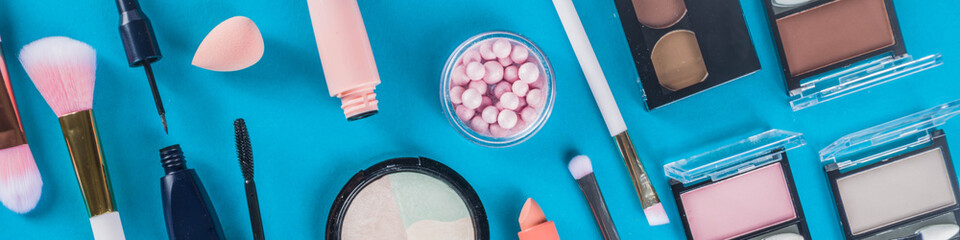 Professional makeup cosmetic set, with summer tropical leaves, woman bag. Make up items. luxury decorative cosmetics flatlay, top view, mockup. Beauty blogger concept. Trendy turquoise background