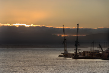 Two shipping cranes at the Bell Bay port in Tasmania at sunset, Australia.