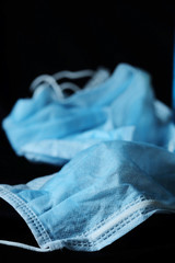 Used contaminated infection prevention single used face mask on black background and space for write wording, waste management must be highly concerned to reduce virus distribution