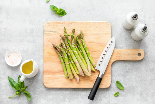 Asparagus cooking concept, top down view on a cutting board with fresh bunch of asparagus, lying down on a kitchen table