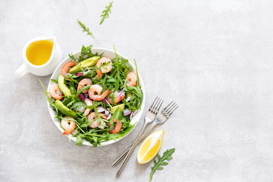 Shrimps avocado and arugula salad, ready to eat healthy and nutritious recipe, overhead view