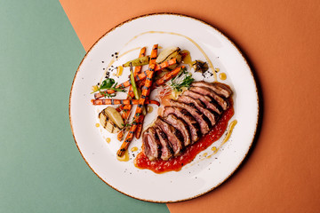 Delicious sliced grilled duck breast with fresh sauce.  closeup of professionally prepared food....