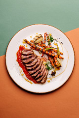 Delicious sliced grilled duck breast with fresh sauce.  closeup of professionally prepared food. top view from above