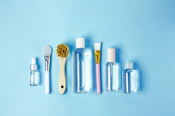 Natural skin care. Composition of organic cosmetics and accessories on a blue background, cosmetic bottles, makeup brushes, body brushes, serums, copy space, flat lay, top view