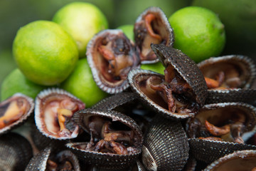 Fresh black shells with limes at a local market