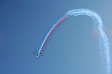 Planes formation performing stunts and spectacular maneuvers in the air, red, blue and white smoke,...