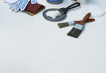 Home Repair and Building Concept. Spatula, Putty Paste, Sandpaper, Paint Brush, Working Gloves on Textured Background
