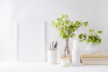 Home interior with decor elements. Mockup with a white frame, spring flowers in a vase on a light...